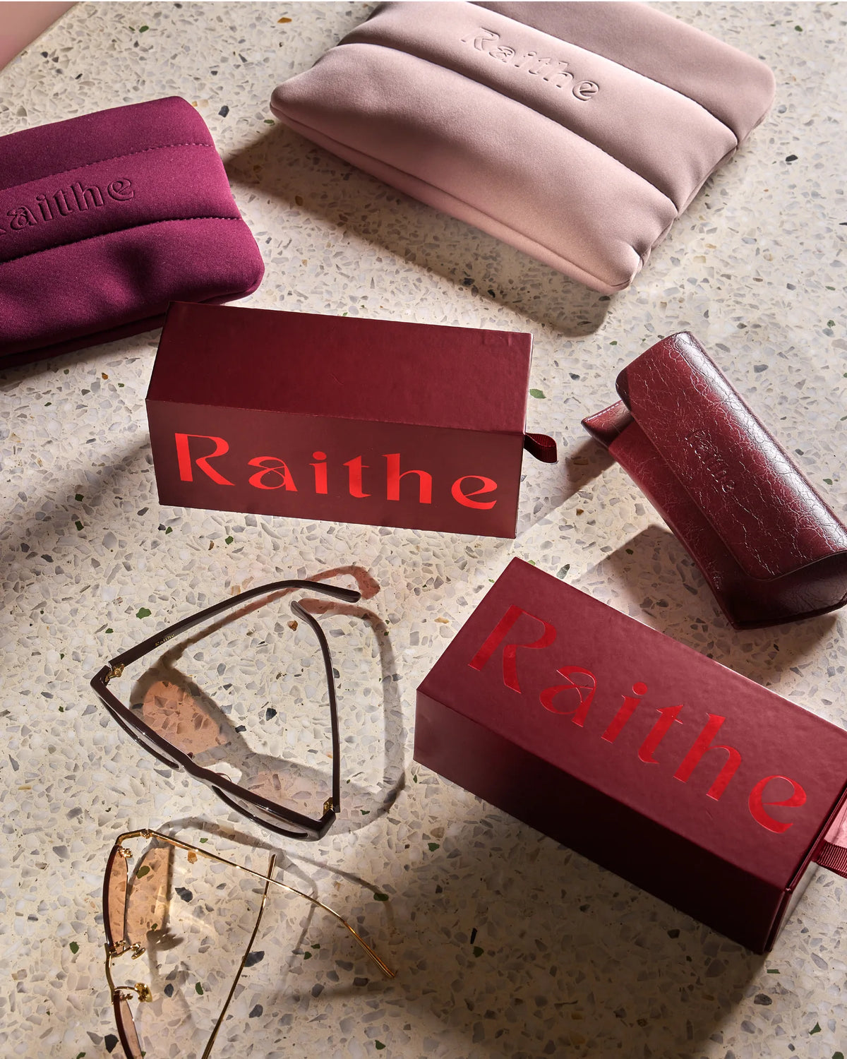 Raithe boxes, pouches and a case on terrazzo